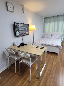 a room with a table and chairs and a bed at White Stay in Seoul