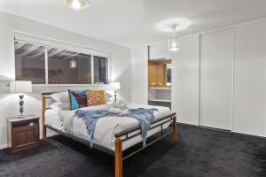 Un dormitorio con una cama con un osito de peluche. en HAZE18 - Sunny Shorefront Retreat Uninterrupted Ocean Views, en Quinns Rocks