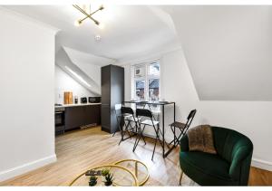 a living room with a green couch and a table at Awesome Loft Flat - Seconds to London’s Best Park! in London
