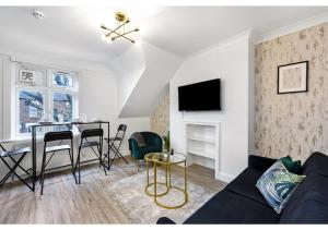 a living room with a couch and a table at Awesome Loft Flat - Seconds to London’s Best Park! in London