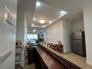Il comprend une cuisine équipée d'un réfrigérateur et d'une table. dans l'établissement หาดช้างเผือกเจ้าสำราญ Chang Phueak Chao Samran Beach, à Haad Chao Samran