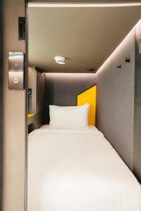 een groot wit bed in een kleine kamer bij Capsule Transit Sleep Lounge KLIA T1 - Landside in Sepang