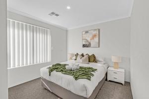 a white bedroom with a large bed and a window at MOSS1 - Bunbury Chic Villa Retreat by the Beach in Bunbury