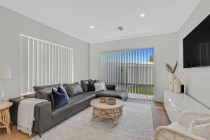 a living room with a couch and a table at MOSS1 - Bunbury Chic Villa Retreat by the Beach in Bunbury