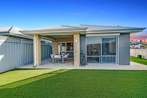 a home with a patio with a table and a fence at MOSS1 - Bunbury Chic Villa Retreat by the Beach in Bunbury