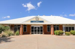 um edifício escolar com um cartaz em cima em The Gidgee Inn em Cloncurry