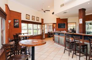 a restaurant with a bar and tables and chairs at The Gidgee Inn in Cloncurry