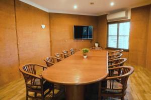 uma sala de conferências com uma mesa de madeira e cadeiras em The Gidgee Inn em Cloncurry