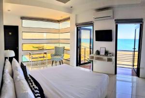 1 dormitorio con cama y vistas al océano en Blue Coast Beach Hotel, en Santa Ana