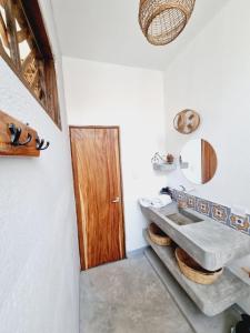 La salle de bains est pourvue d'un lavabo et d'une porte en bois. dans l'établissement Villa Makai 1 Orange, à El Paredón Buena Vista