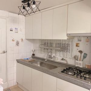 a kitchen with white cabinets and a sink at Stay Cheongnyang in Seoul