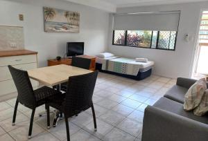 a living room with a table and a bed at Palm Waters Holiday Villas in Townsville
