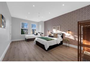 1 dormitorio grande con 2 camas y pared en Astonishing 4BR House - Perfect for a Big Family, en Southend-on-Sea