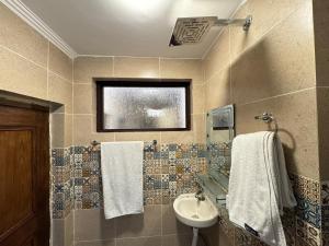 een badkamer met een wastafel, een toilet en handdoeken bij Hotel Jafson Accommodates in Srinagar