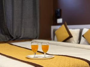 twee glazen bier op een bord op een bed bij Hotel Jafson Accommodates in Srinagar