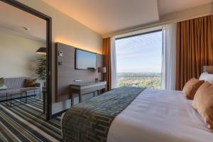 a hotel room with a large bed and a large window at Leonardo Royal Hotel Amsterdam in Amsterdam