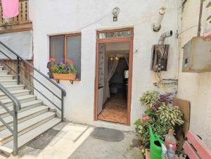 un edificio con una escalera y una puerta con flores en Paata's Guesthouse, en Borjomi