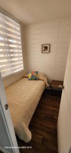 una piccola camera da letto con un letto e una finestra di Departamento en Pucón a Pucón