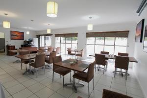 - une salle à manger avec des tables, des chaises et des fenêtres dans l'établissement Chinchilla Downtown Motor Inn, à Chinchilla