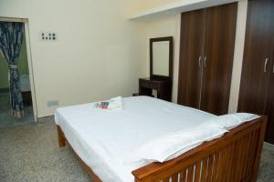 ein Schlafzimmer mit einem Bett mit einem Spiegel und einer Kommode in der Unterkunft Live Inn RMS in Tiruchchirāppalli