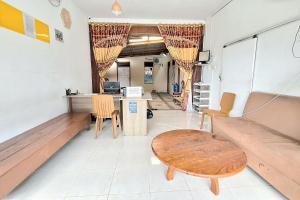 Habitación con bancos, mesa y escritorio. en Handira Homestay Syariah Padang RedPartner, en Duku