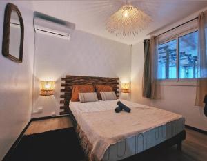 a bedroom with a large bed and a chandelier at Lilie location sud in Petite Île