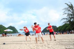 um grupo de pessoas jogando frisbee na praia em Cat Ba Violet Hotel em Ilha de Cát Bà