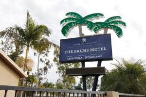 a sign for the palms motel with palm trees at The Palms Motel in Chinchilla