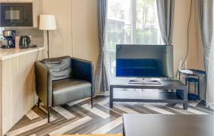 een woonkamer met een tv, een stoel en een bureau bij 2 Bedroom Lovely stacaravan In Harderwijk in Harderwijk