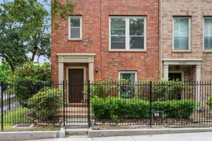 a brick house with a black fence in front of it at Luxury TownHouse Next to Downtown in Houston