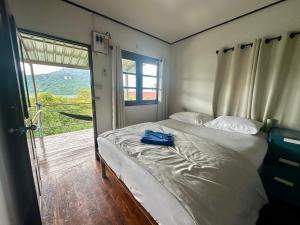 a bedroom with a bed and a door to a balcony at Hilltop view - Phi Phi in Phi Phi Islands
