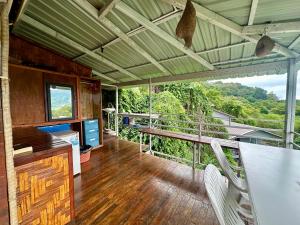 a room with a table and chairs and a balcony at Hilltop view - Phi Phi in Phi Phi Islands