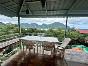 una mesa y sillas en una terraza con montañas al fondo en Hilltop view - Phi Phi, en Islas Phi Phi