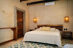 1 dormitorio con cama blanca y alfombra azul en Mero Mero Hotel, en El Cuyo