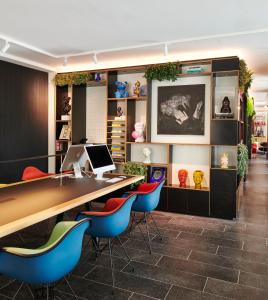 an office with a desk and blue chairs at citizenM Rome Isola Tiberina in Rome