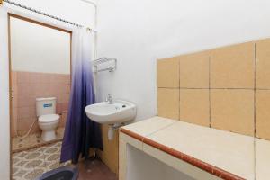 y baño con lavabo y aseo. en RedDoorz Syariah near Institut Darmajaya Lampung, en Bandar Lampung