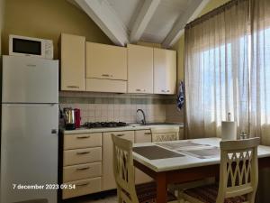 a kitchen with a white refrigerator and a table with chairs at Plaza Top floor apartment in Santa Maria