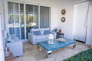 a living room with a couch and a table at Riviera Azul -2 Hab con vista a la Piscina in San Felipe de Puerto Plata