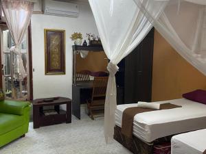 - une chambre avec un lit et une chaise dans l'établissement Nola's Homestay, à Kampungdurian