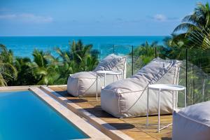 a resort with chairs and a pool and the ocean at Mero Mero Hotel in El Cuyo