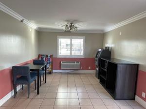 a living room with a table and a refrigerator at Diamond Inn in North Hills