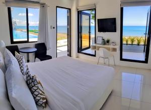 1 dormitorio con cama y vistas al océano en Blue Coast Beach Hotel, en Santa Ana