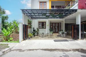 een huis met een patio met tafels en stoelen bij Bisma Balcony Homestay in Jetis