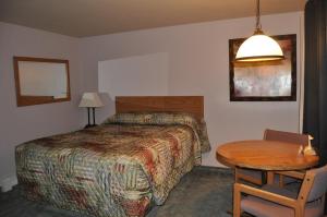 une chambre d'hôtel avec un lit et une table dans l'établissement Moriah Motel, à Sheridan