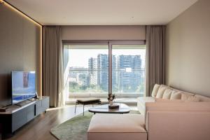 a living room with a couch and a large window at Artisse Place - Access to 4000 sqm Fusion Wellness Centre and 800 sqm Indoor Swimming Pool in Shenzhen