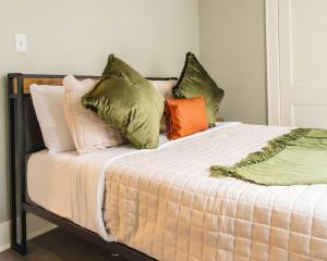 una cama con varias almohadas encima en Dundee Escape, en Charleston