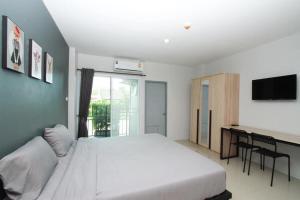 um quarto com uma grande cama branca e uma secretária em Around Loei em Loei