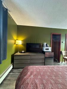 a room with a bed and a tv and a microwave at Town and Country Motel in Nipigon