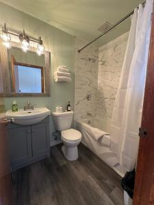 a bathroom with a sink and a toilet and a bath tub at Town and Country Motel in Nipigon