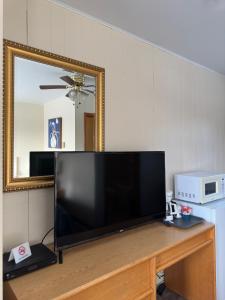 Une télévision à écran plat est installée au-dessus d'une table en bois. dans l'établissement Town and Country Motel, à Nipigon
